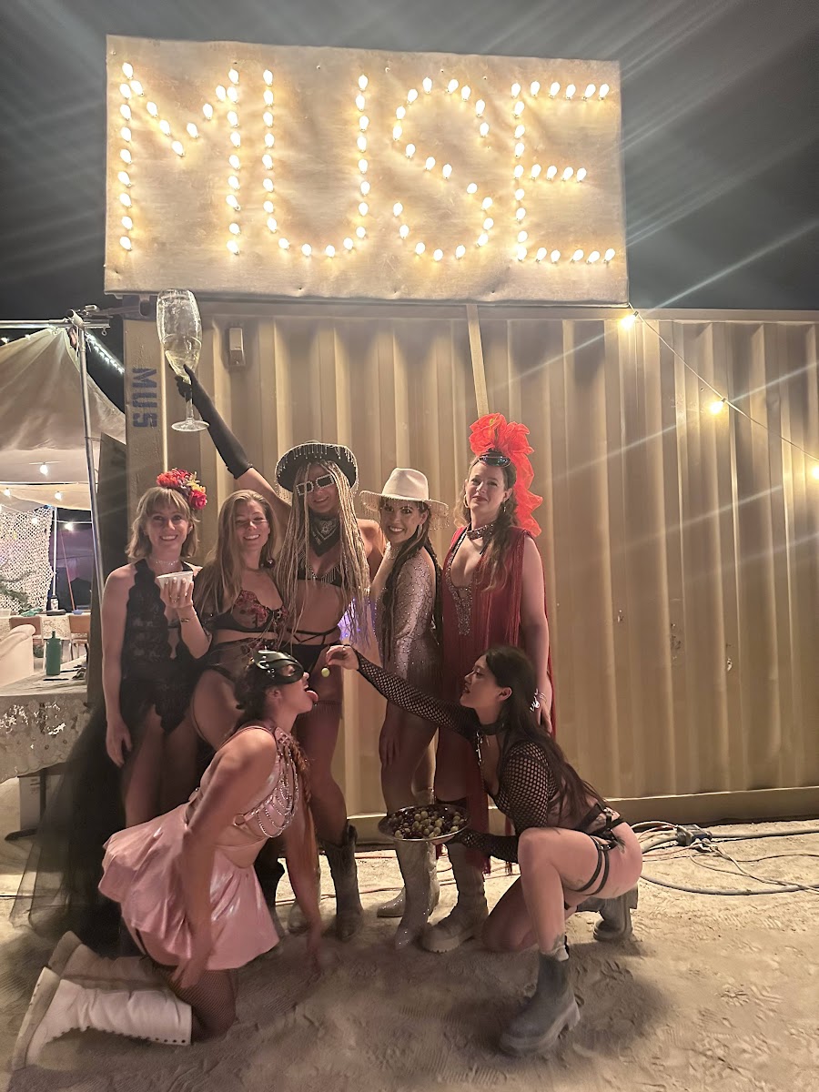 Muse Cafe founders and campmates under the Muse sign